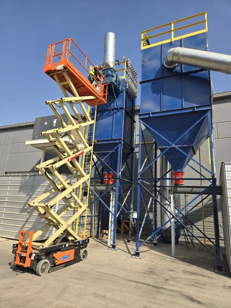 A man on a scissor lift next to a building.