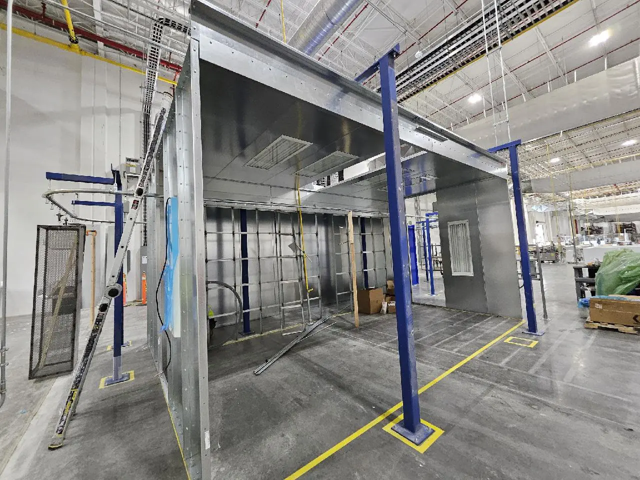 A large room with many shelves and blue poles.